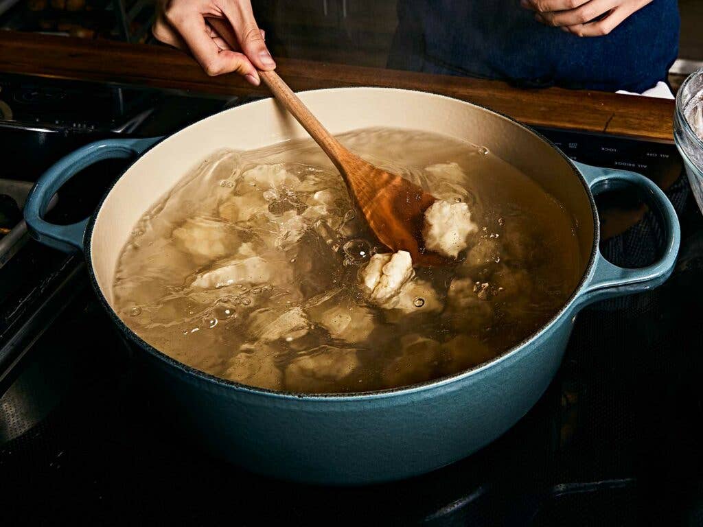 Dumplings boiling in pot.