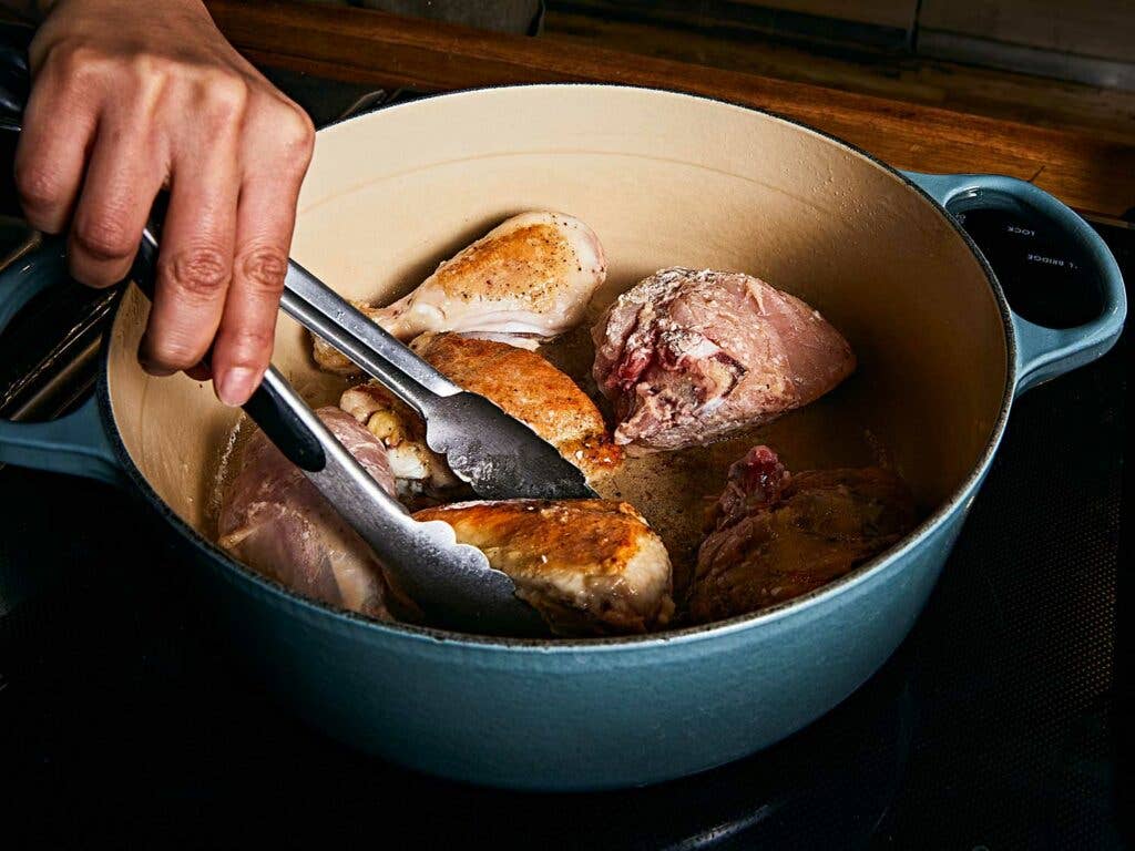 Cooking chicken in pot to sear.