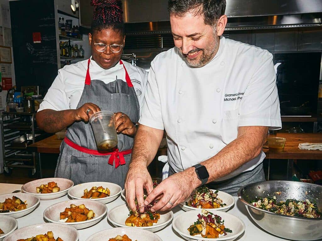 Sous chef Aretah Ettarh and executive chef Michael Anthony plate the first course: fall squash salad with burrata and hazelnuts.