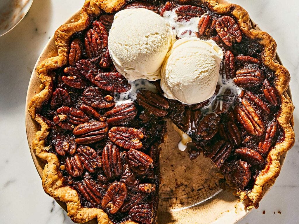 Scoops of vanilla ice cream on top of the chocolate bourbon pecan pie.