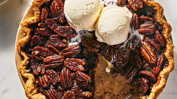 Scoops of vanilla ice cream on top of bourbon chocolate pecan pie.
