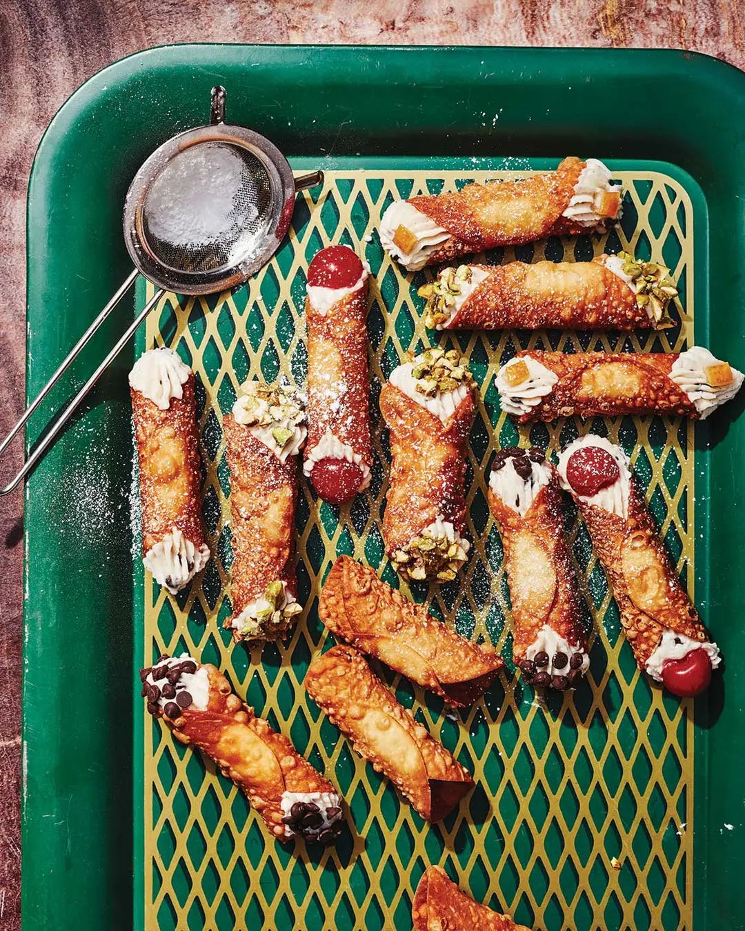 Sicilian Cannoli Cannolis with chocolate chips, raw pistachios, candied orange peels, and maraschino cherries.