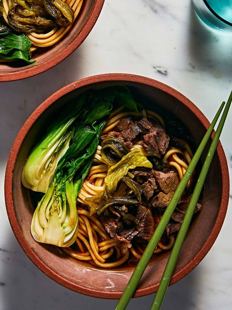 Blanched baby bok choy and pickled Chinese greens in Taiwanese beef noodle soup.