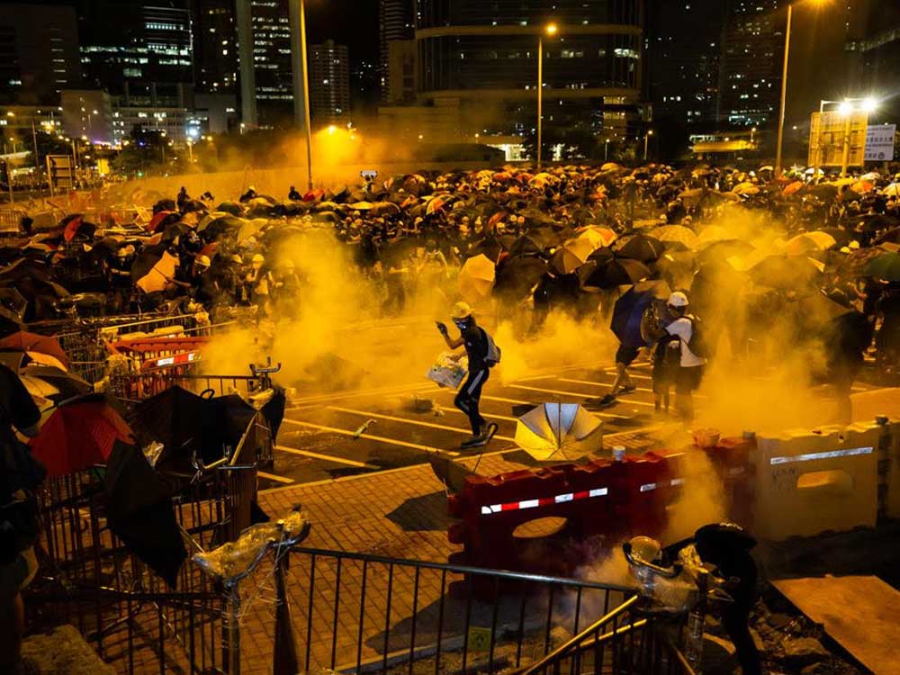 A photo of Hong Kong police firing tear gas into a crowd of protestors, taken this past summer by chef Todd Darling.