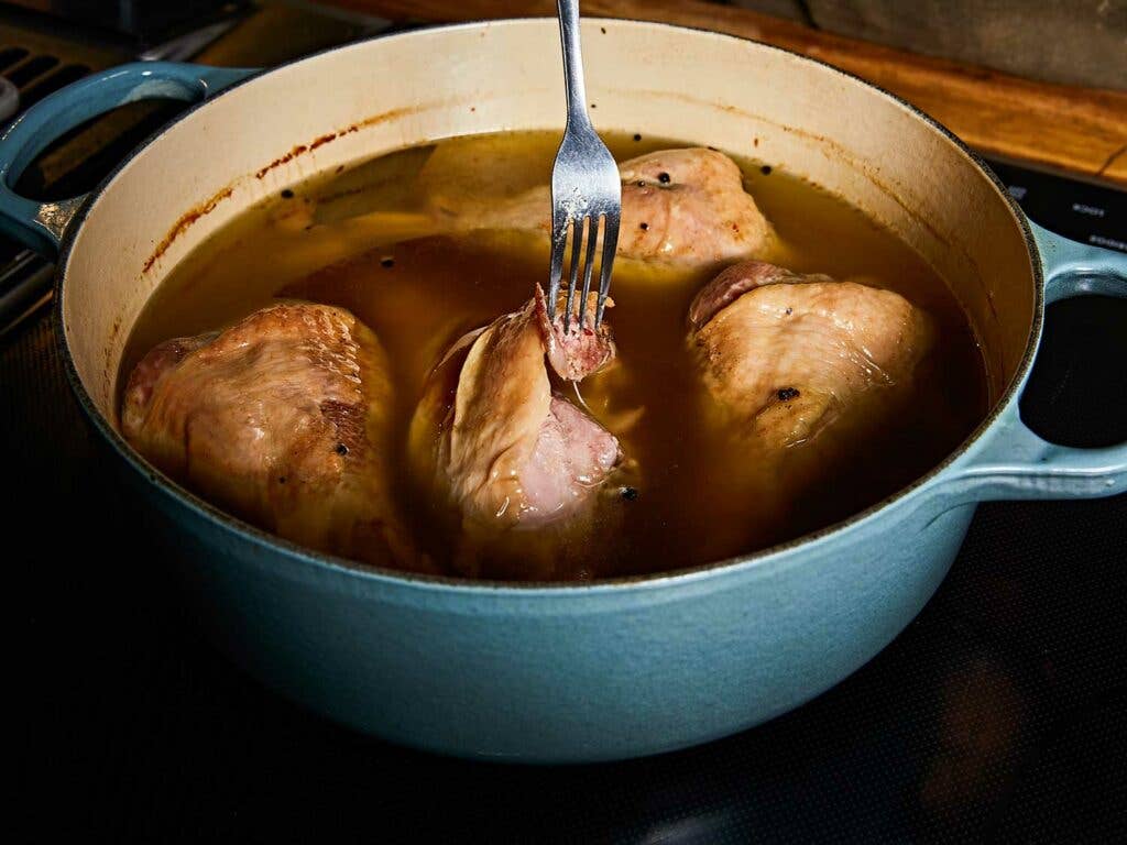 Drumsticks cooled in pot with their cooking fat.