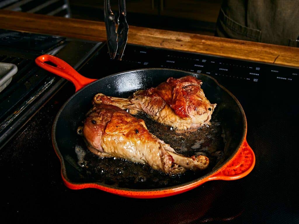 Searing turkey skin to brown and crisp in a hot skillet.