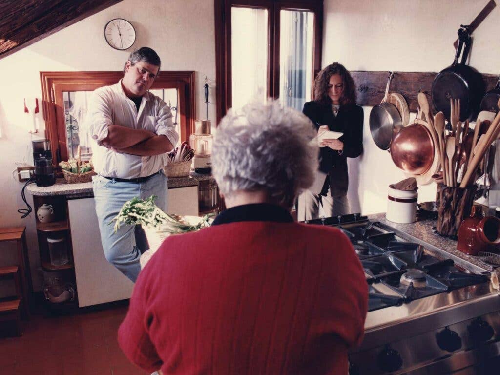 Saveur’s first editor-in-chief, ­Dorothy Kalins (right), and executive editor, Colman Andrews, in the Venice, Italy, kitchen of the late Marcella Hazan, whose back is toward the camera.