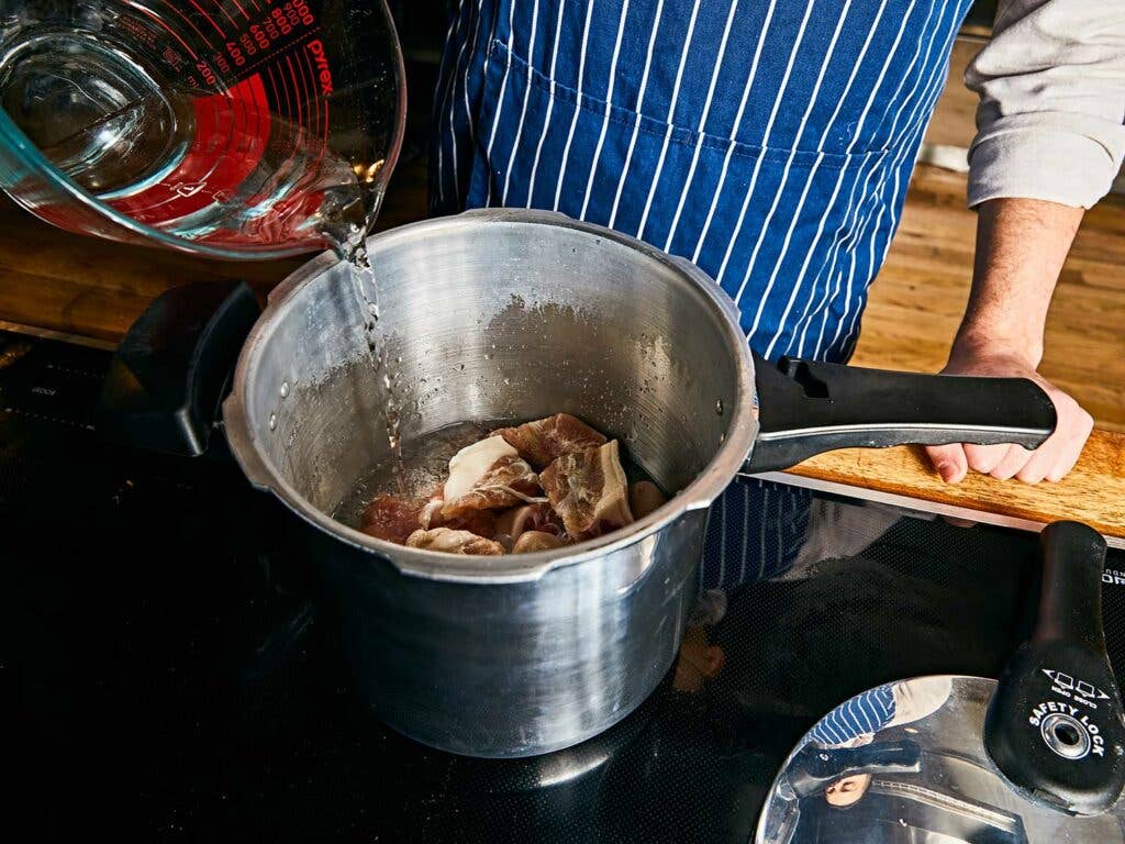 Pressure cooking salted pigs’ tails.