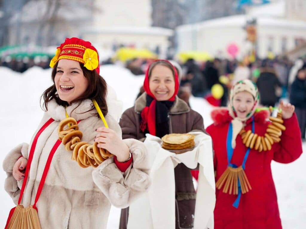 Festival goers celebrate with blinis and necklaces of sushki—an Eastern European sweet bread ring.
