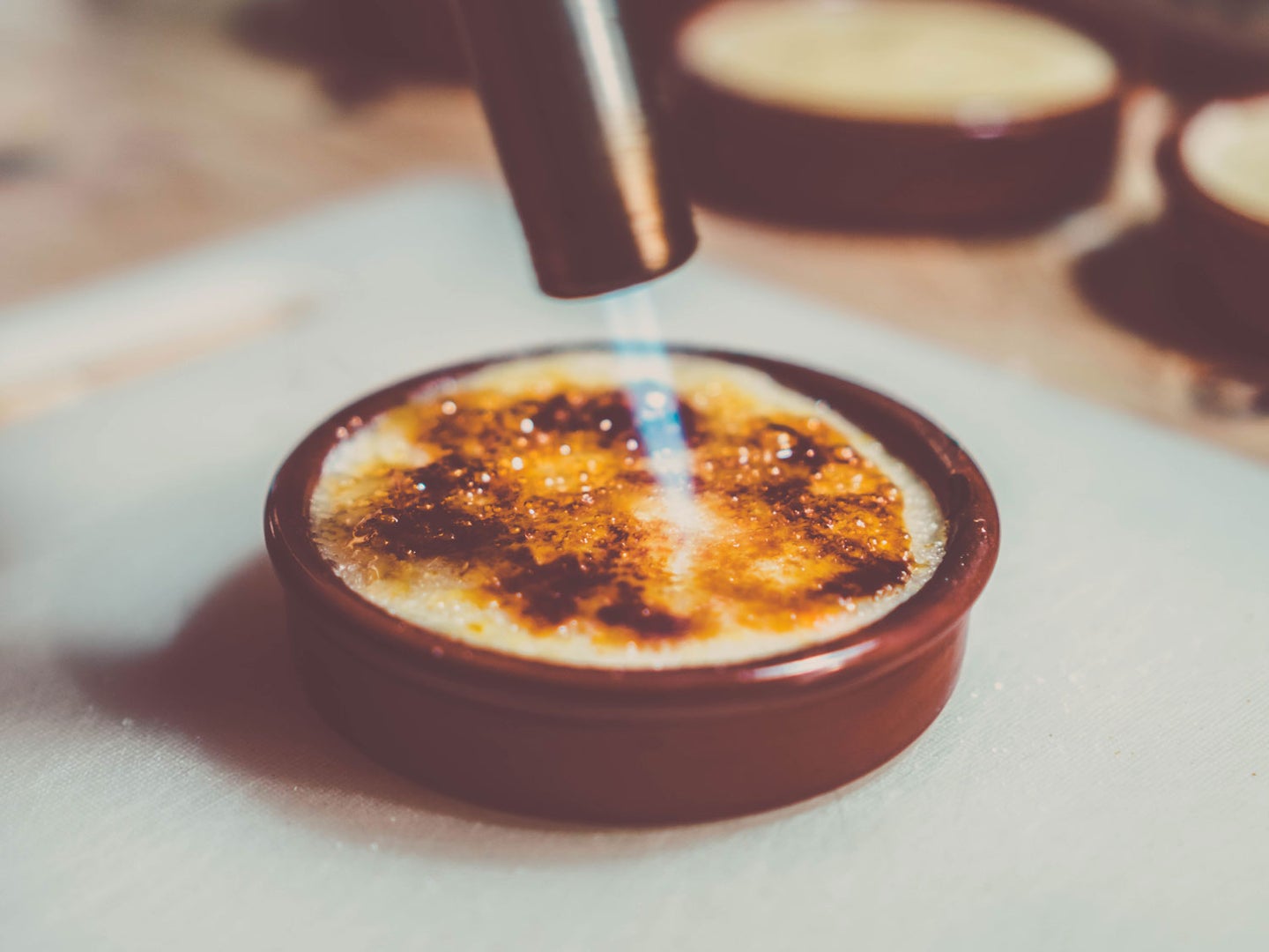 Using blow torch on creme brulee