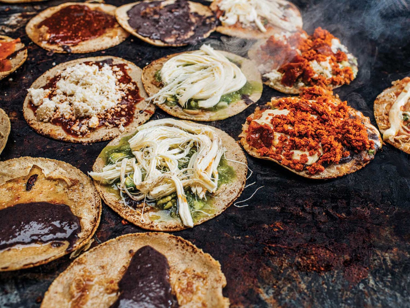 Memelas, sope-like snacks particular to Oaxaca, cook on the comal at Memelas Doña Mago.
