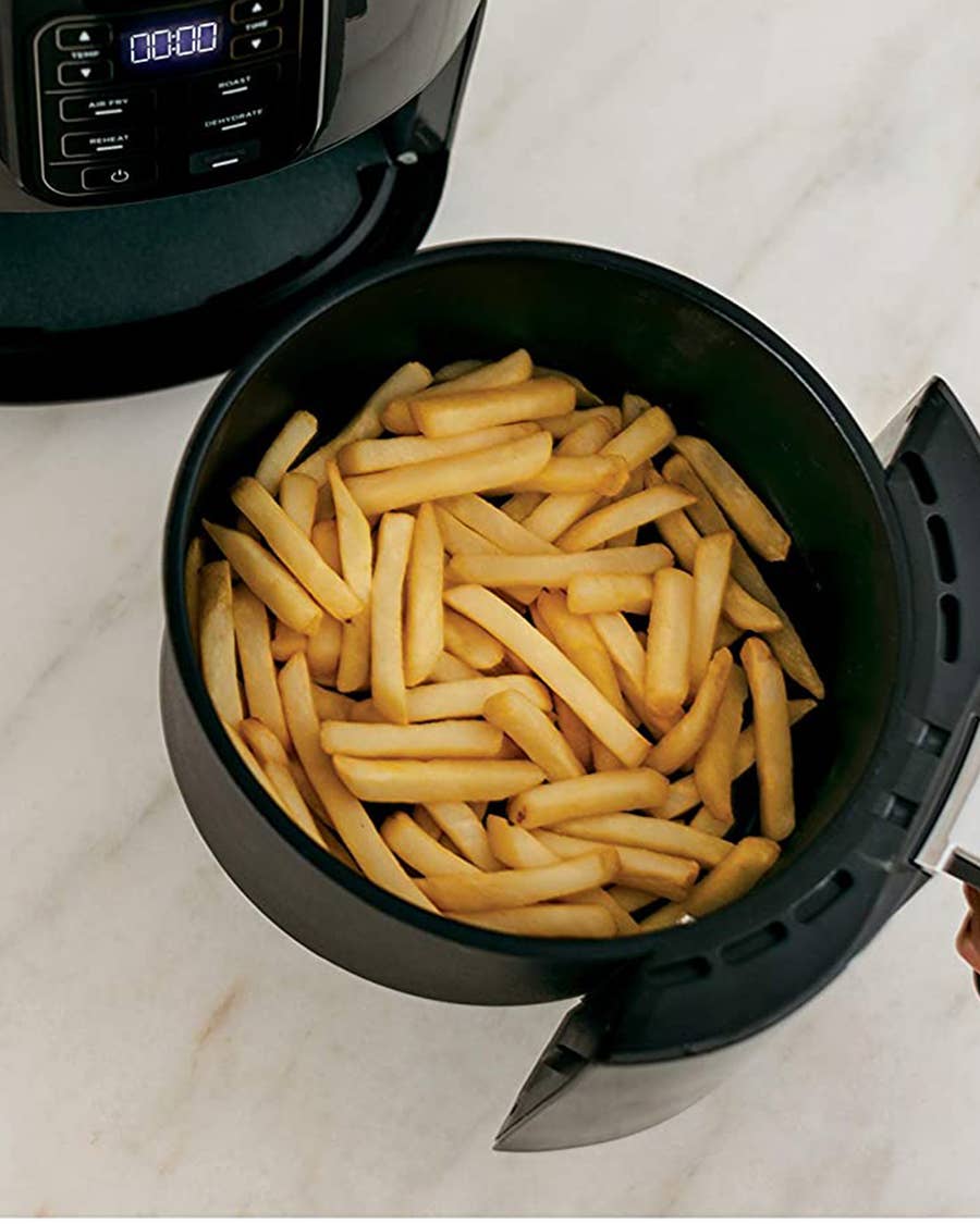Man cooking french fries in an air fryer