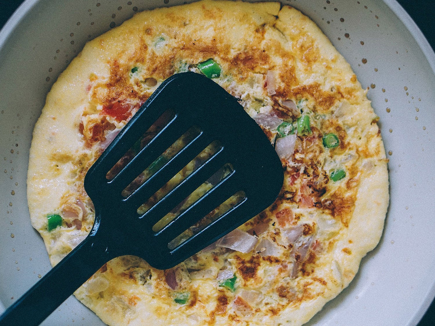 A spatula on top of an omelette