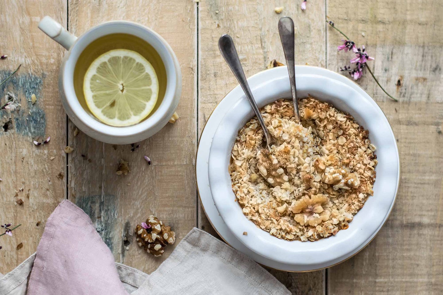 Bowl of oatmeal and cup of tea with lemon.