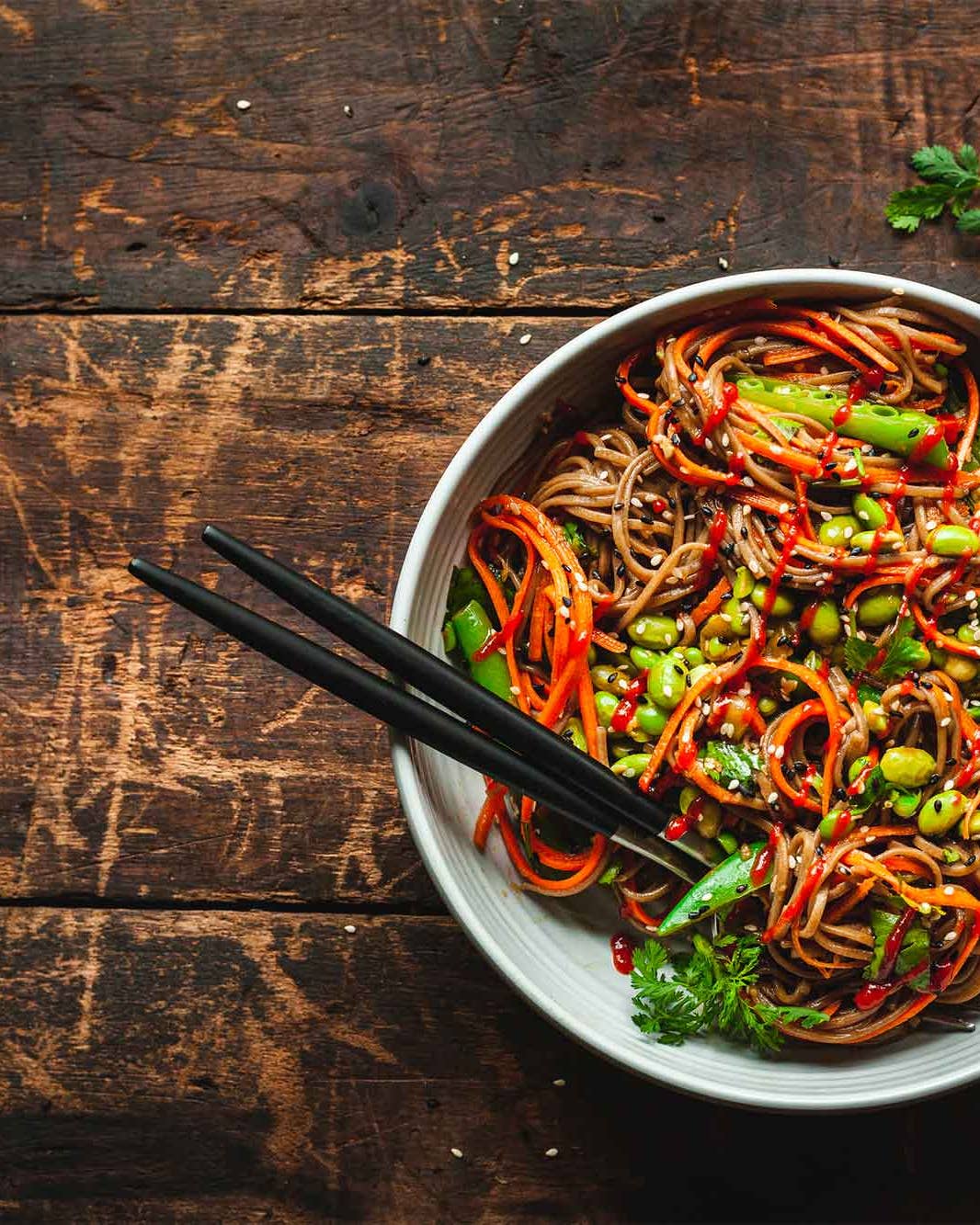 Bowl of noodles and vegetables with chopsticks