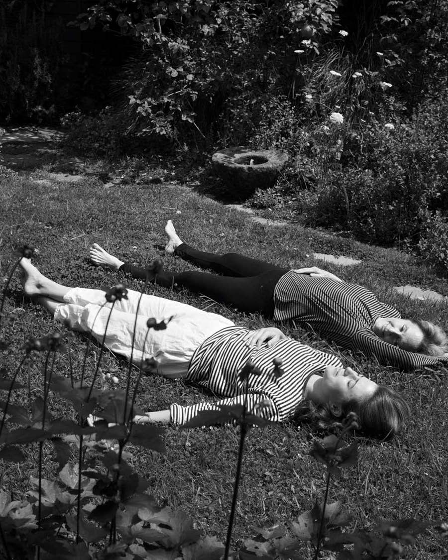 Fanny Singer relaxes in grass with mom Alice Waters at the family home in Berkeley, California.