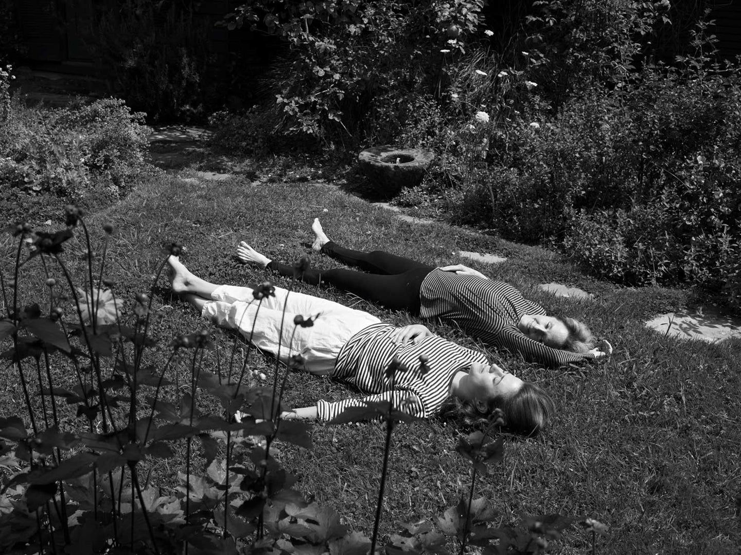 Fanny Singer relaxes in grass with mom Alice Waters at the family home in Berkeley, California.