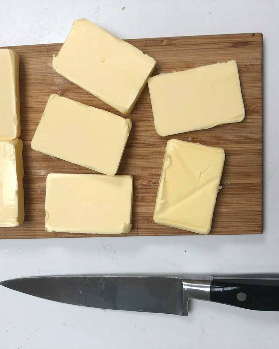 Knife with cheese on cutting board.