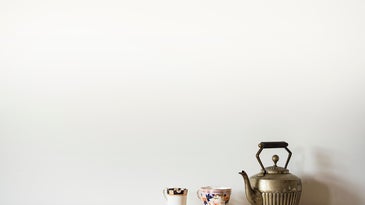 Brass teapot with patterned tea cups.