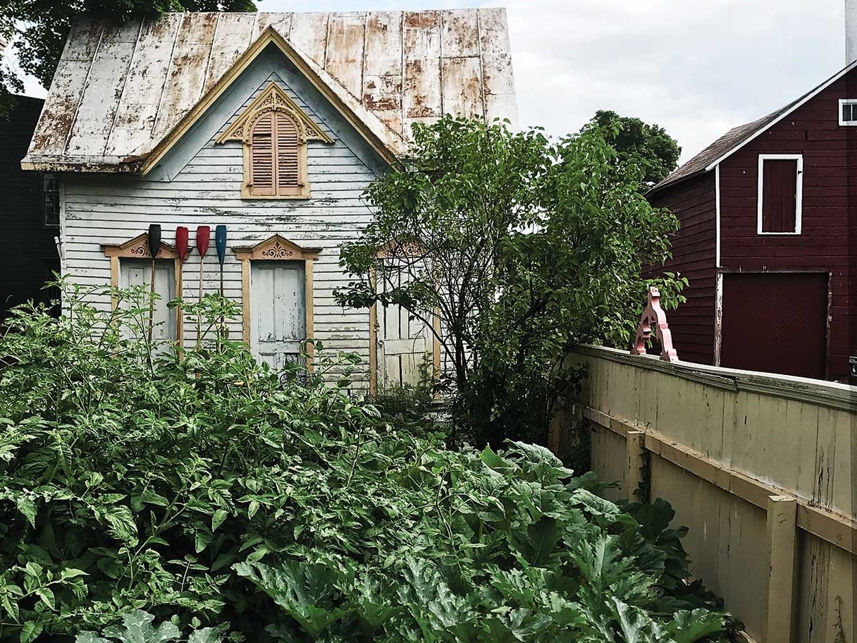 Author Dana Bowen cleared the yard behind her Athens, New York, home to make room for a vegetable garden. The harvest has been plentiful enough to share, so she hangs bags of fresh produce along the fence for neighbors to take.