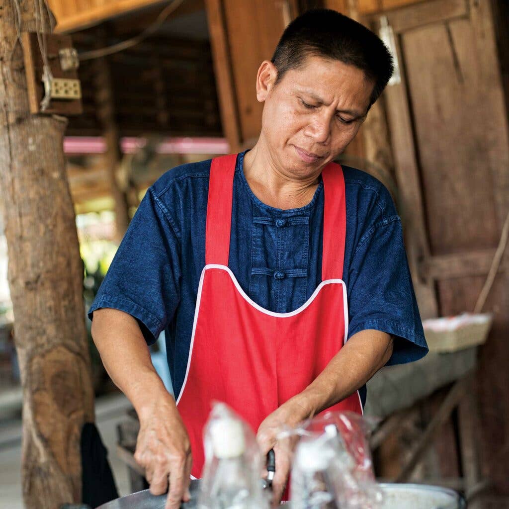 Man wearing red apron and indigo blue shirt