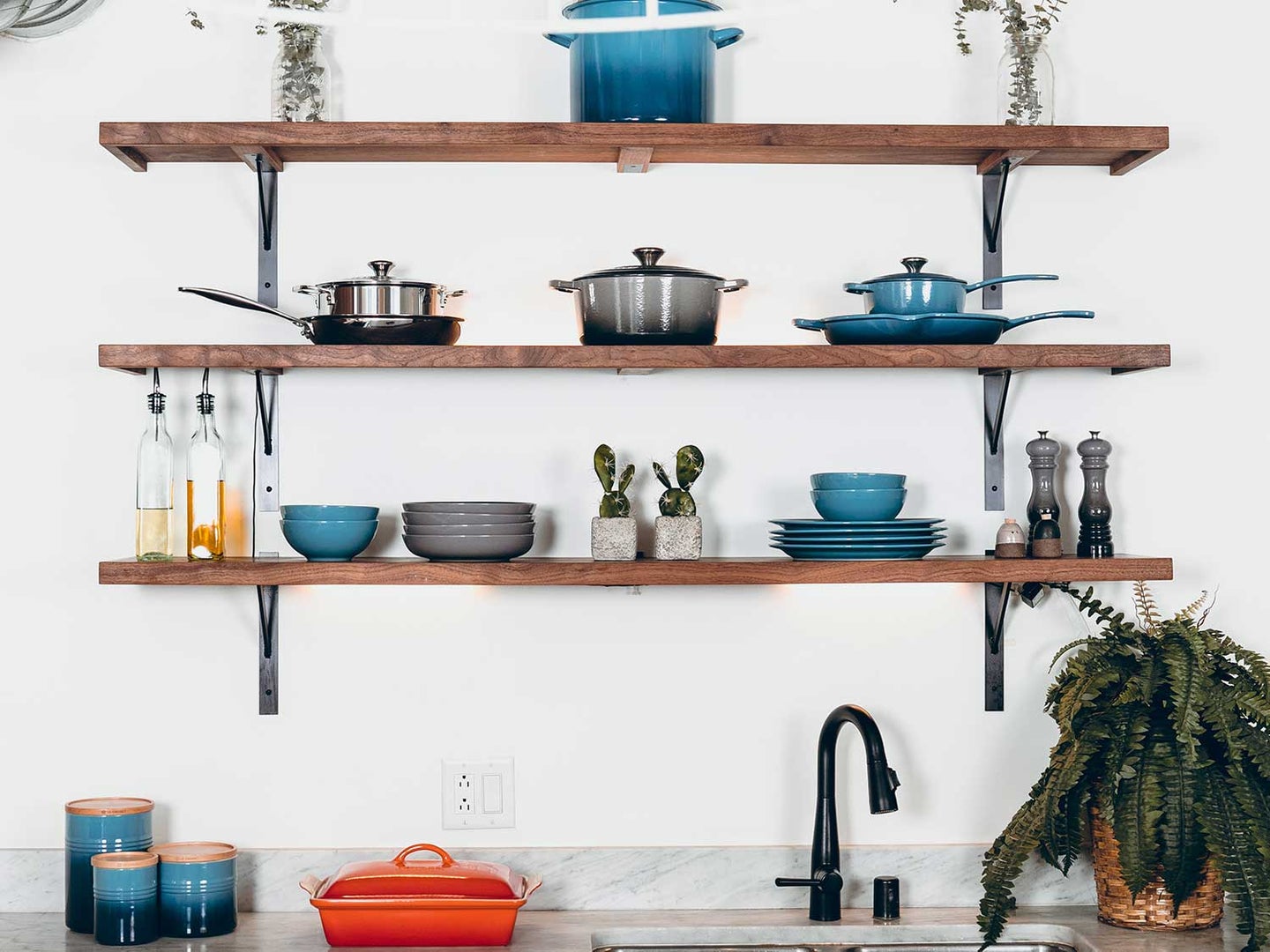 Kitchen utensils hanging about kitchen counter.