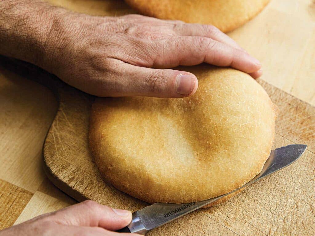 Cutting bread with a serrated knife.