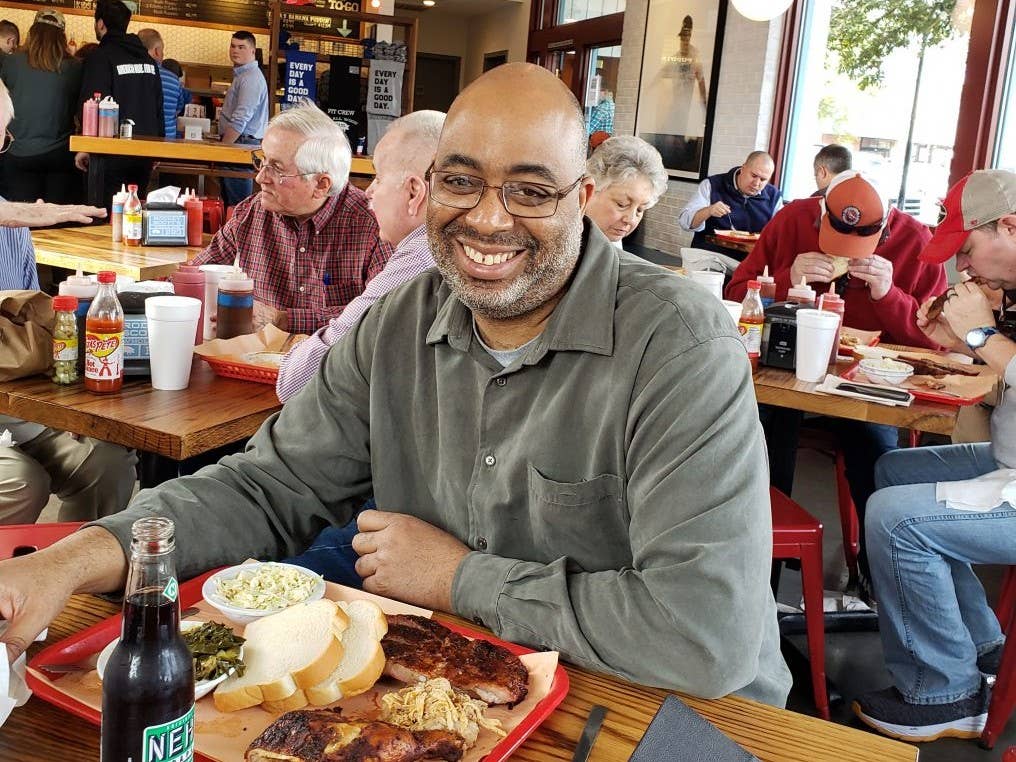 Adrian Miller eating barbecue with tankora seasoning