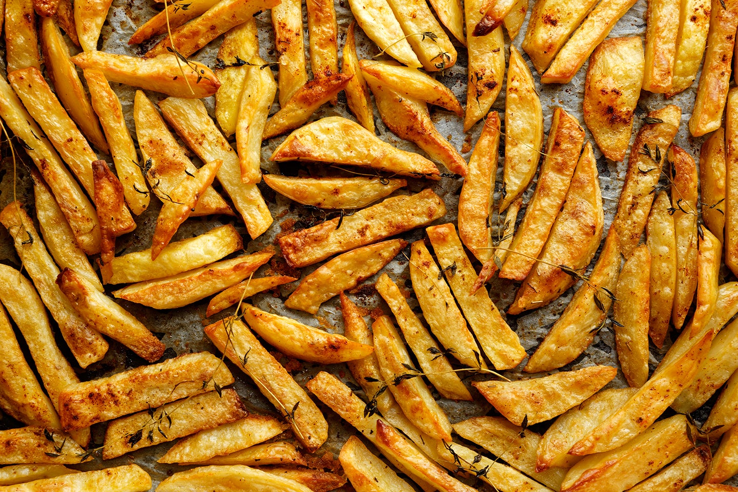 Seasoned fries on a baking sheet.