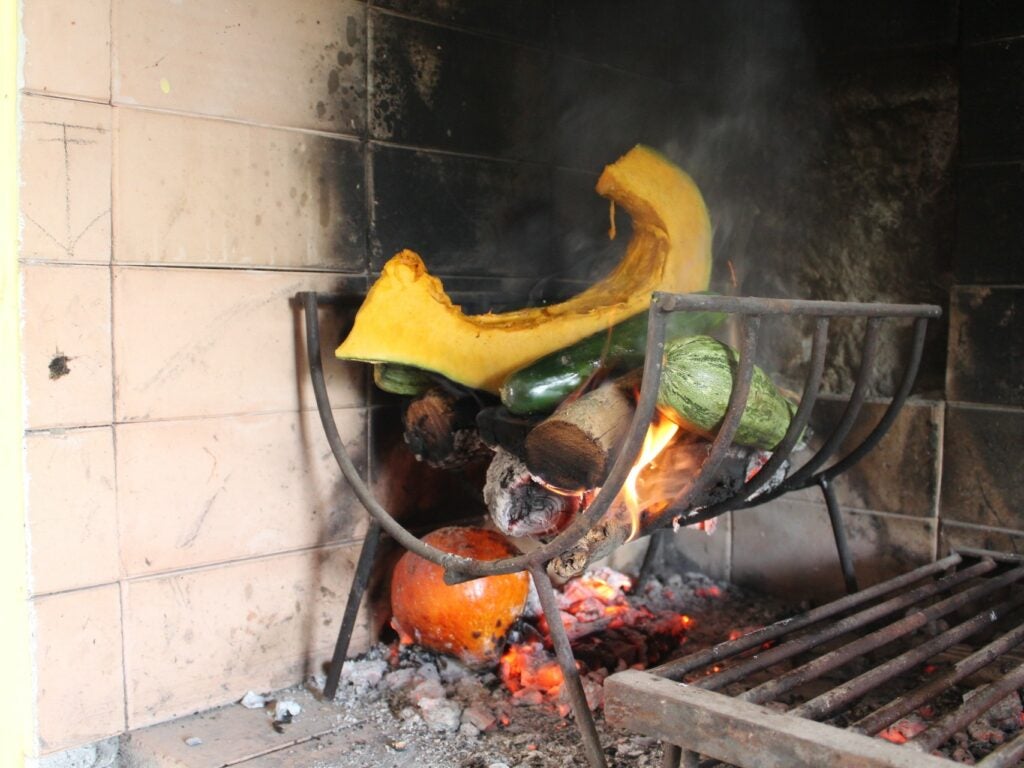 Argentina asando verduras al fuego de leña
