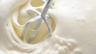 Whipping cream with a mixer. Bubbles on cream