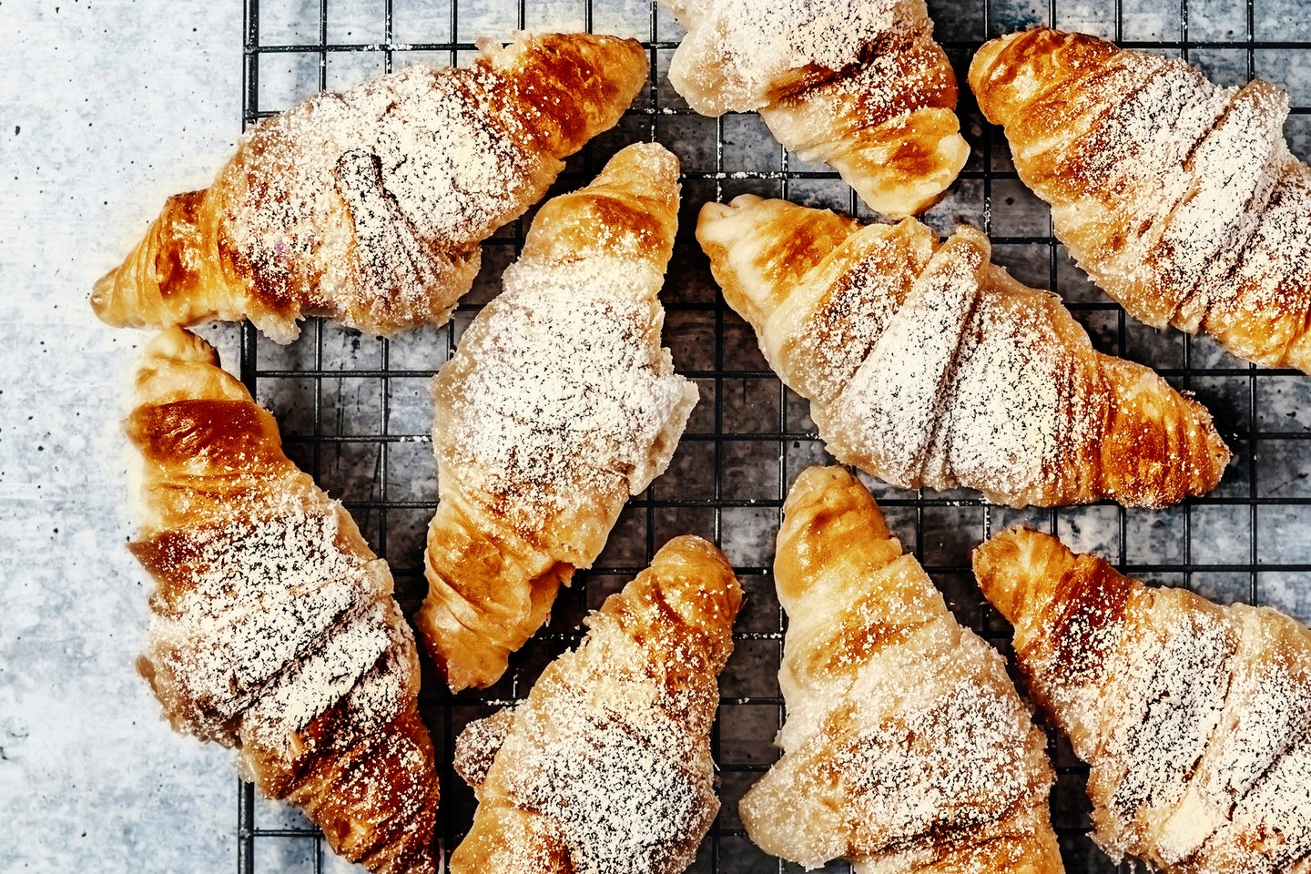 Croissants on a cooling rack on gray background