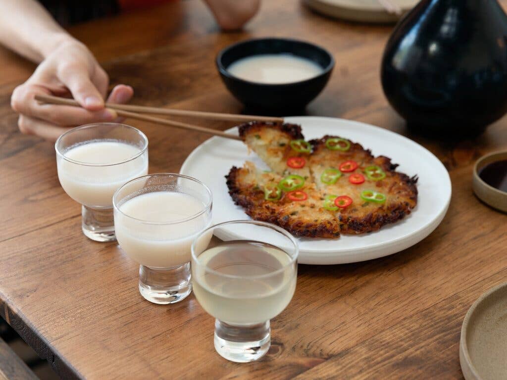 Drinking makgeolli and eating korean pancake