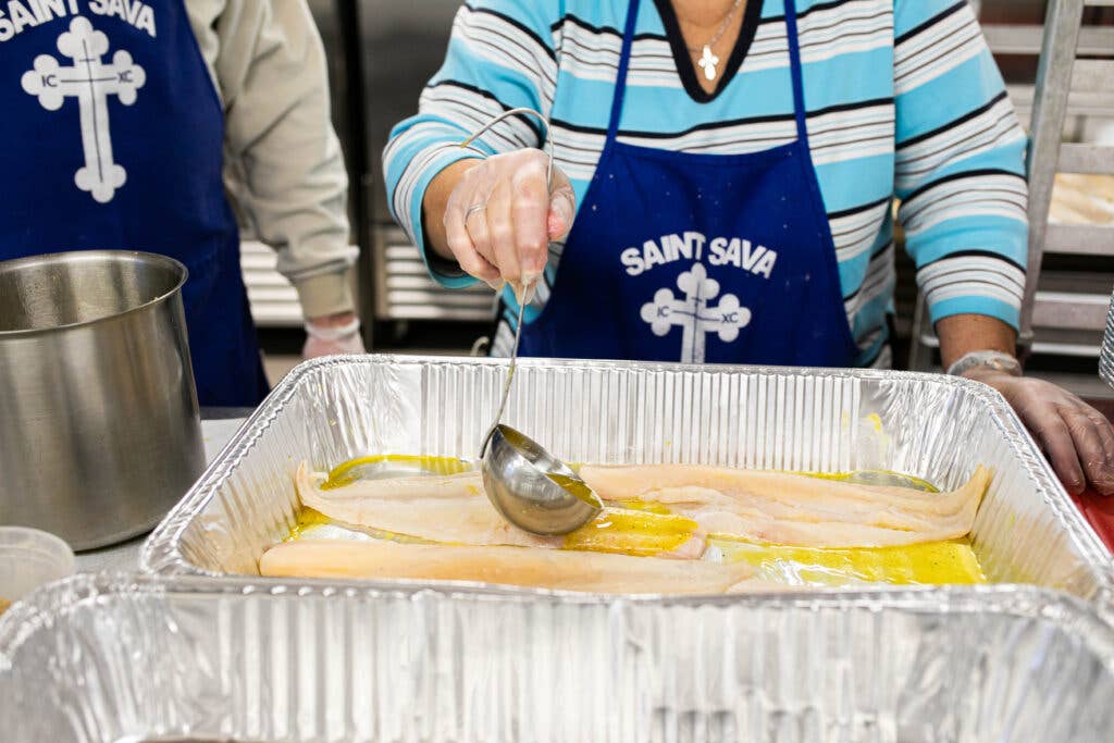 ladling oil over fish filets