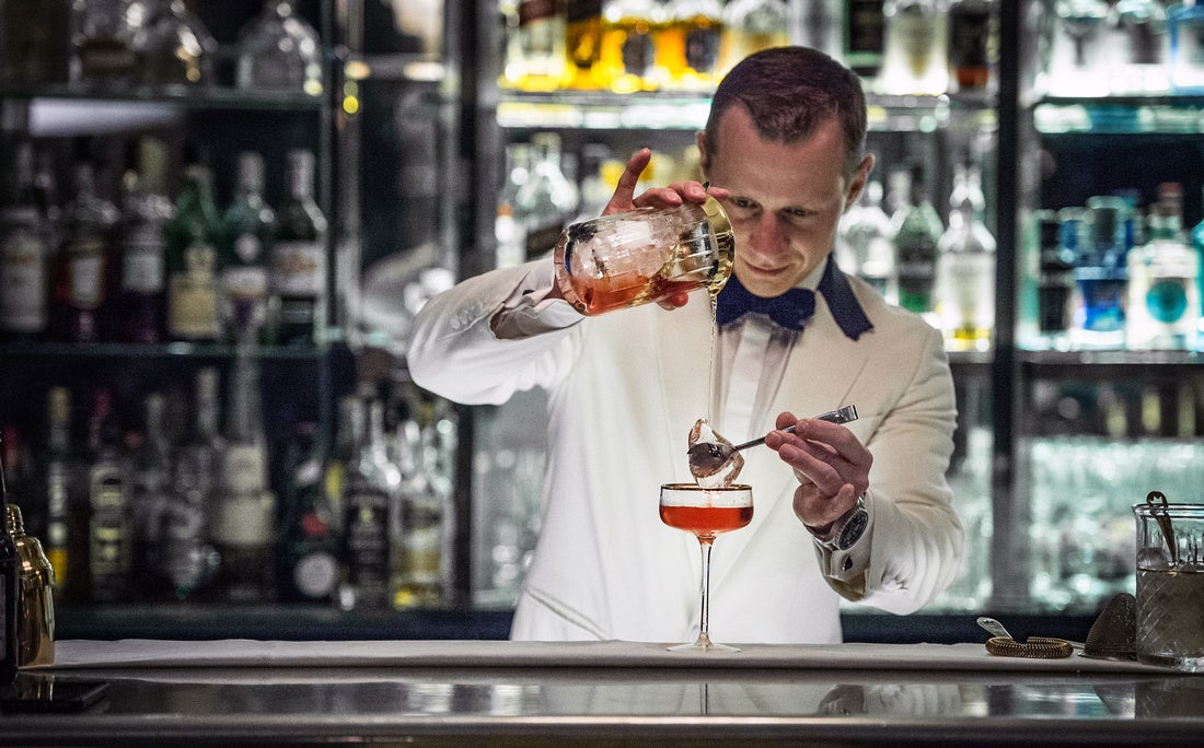 Irish bartender pours whiskey cocktail.