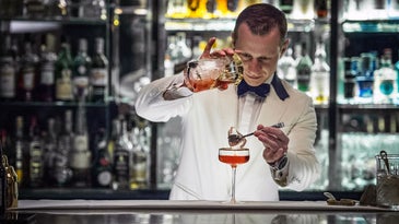 Irish bartender pours whiskey cocktail.