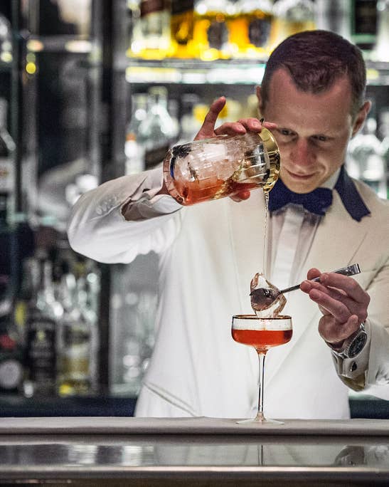 Irish bartender pours whiskey cocktail.