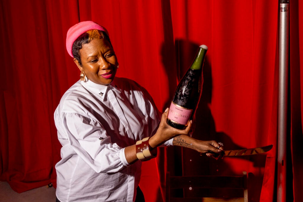 Marvina Robinson, sabering a bottle of Champagne.