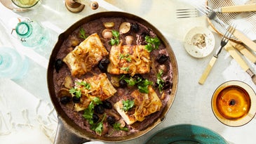 skillet of salt cod on a bed of port-wine onions and potatoes