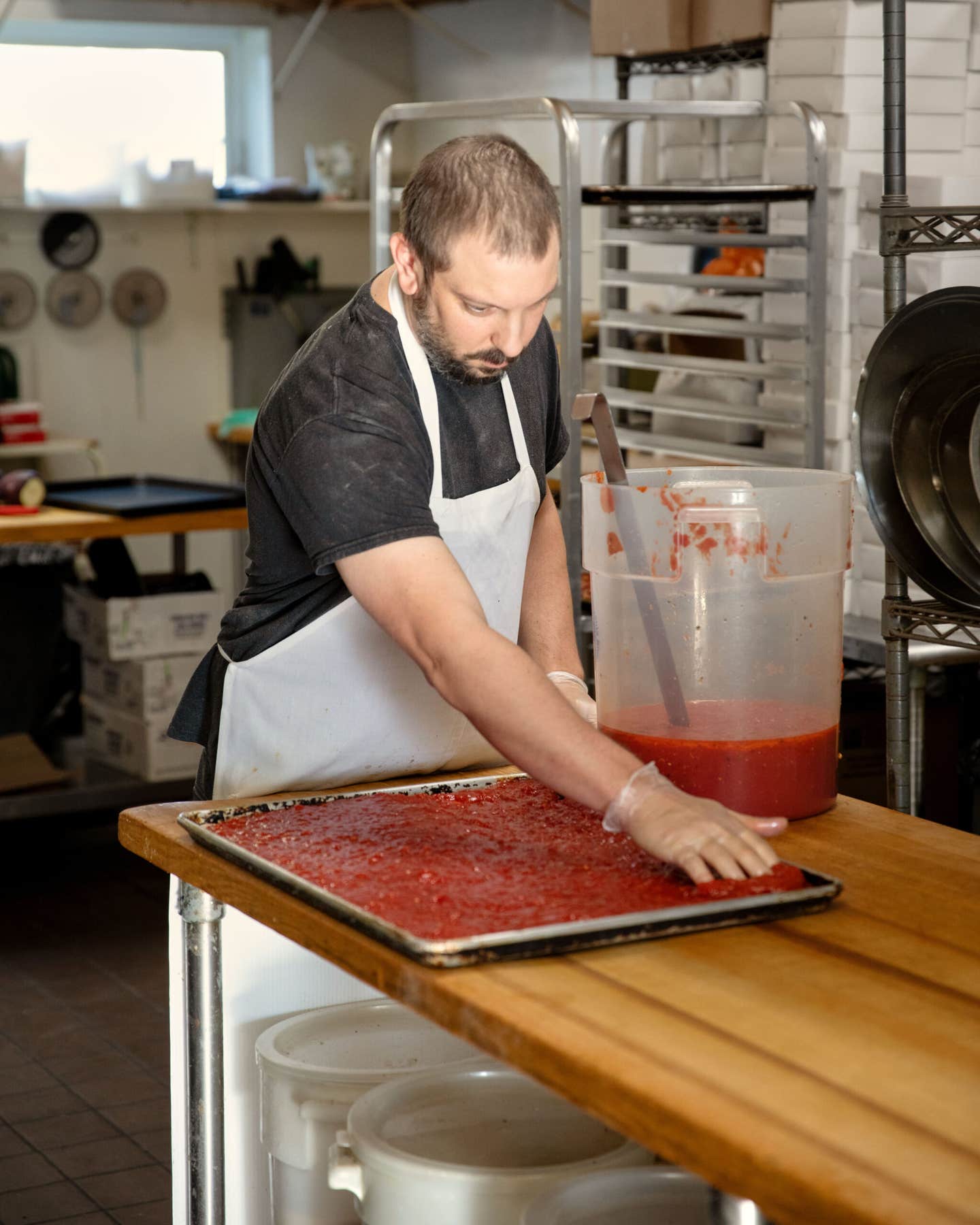 Eric Palmieri sauces a pie at D. Palmieri’s Bakery in Johnston 