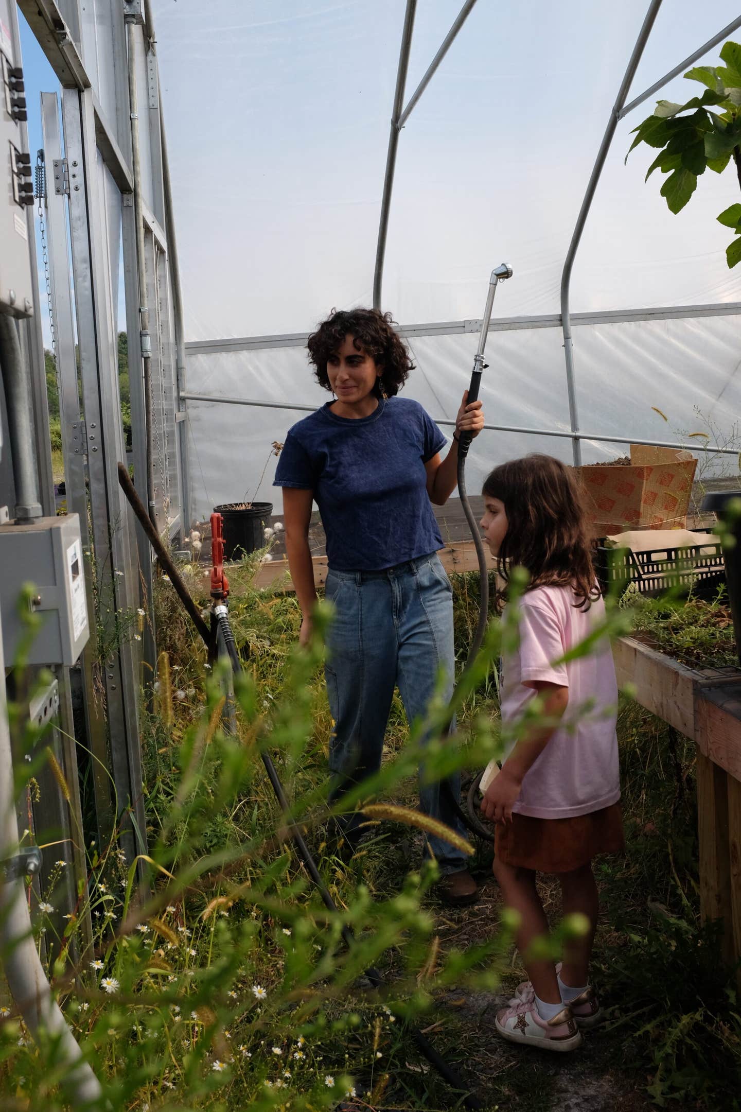Youwakim waters an heirloom fig tree with a young visitor from the Palestinian American Community Center 